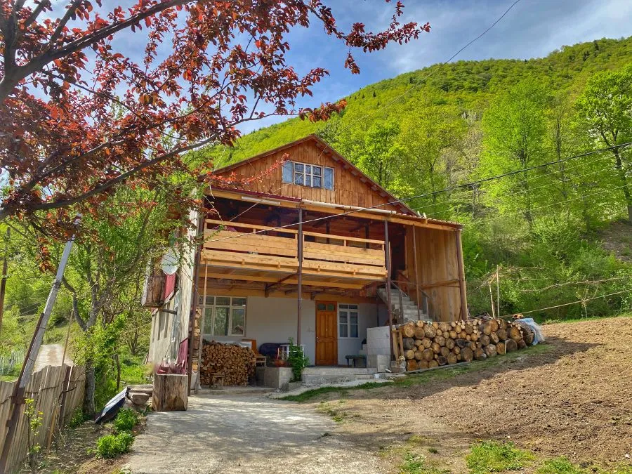 The wooden Family Hotel Khikhani View with firewood stacked by the house