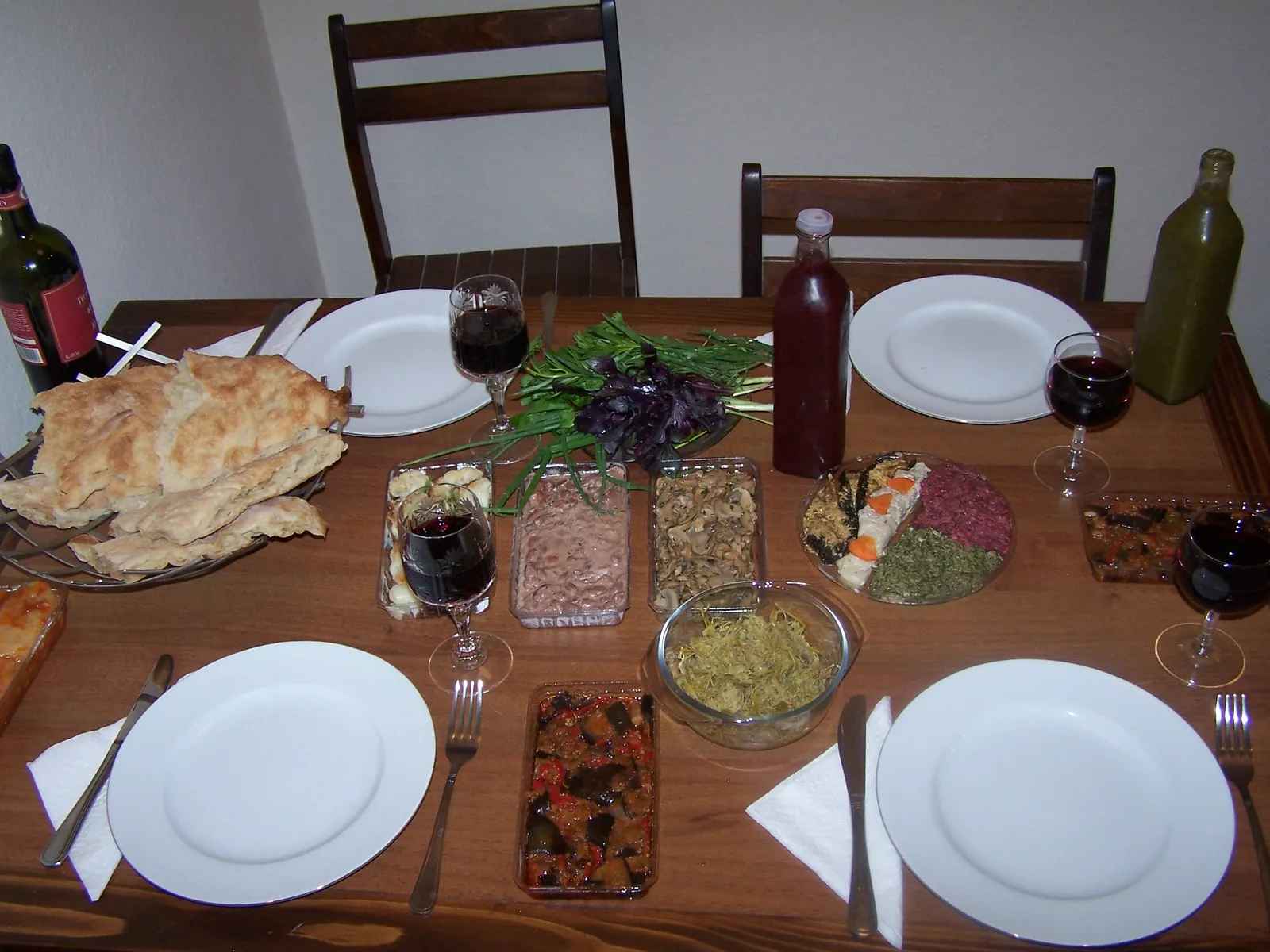 A Georgian feast table covered with shared dishes, bread and wine