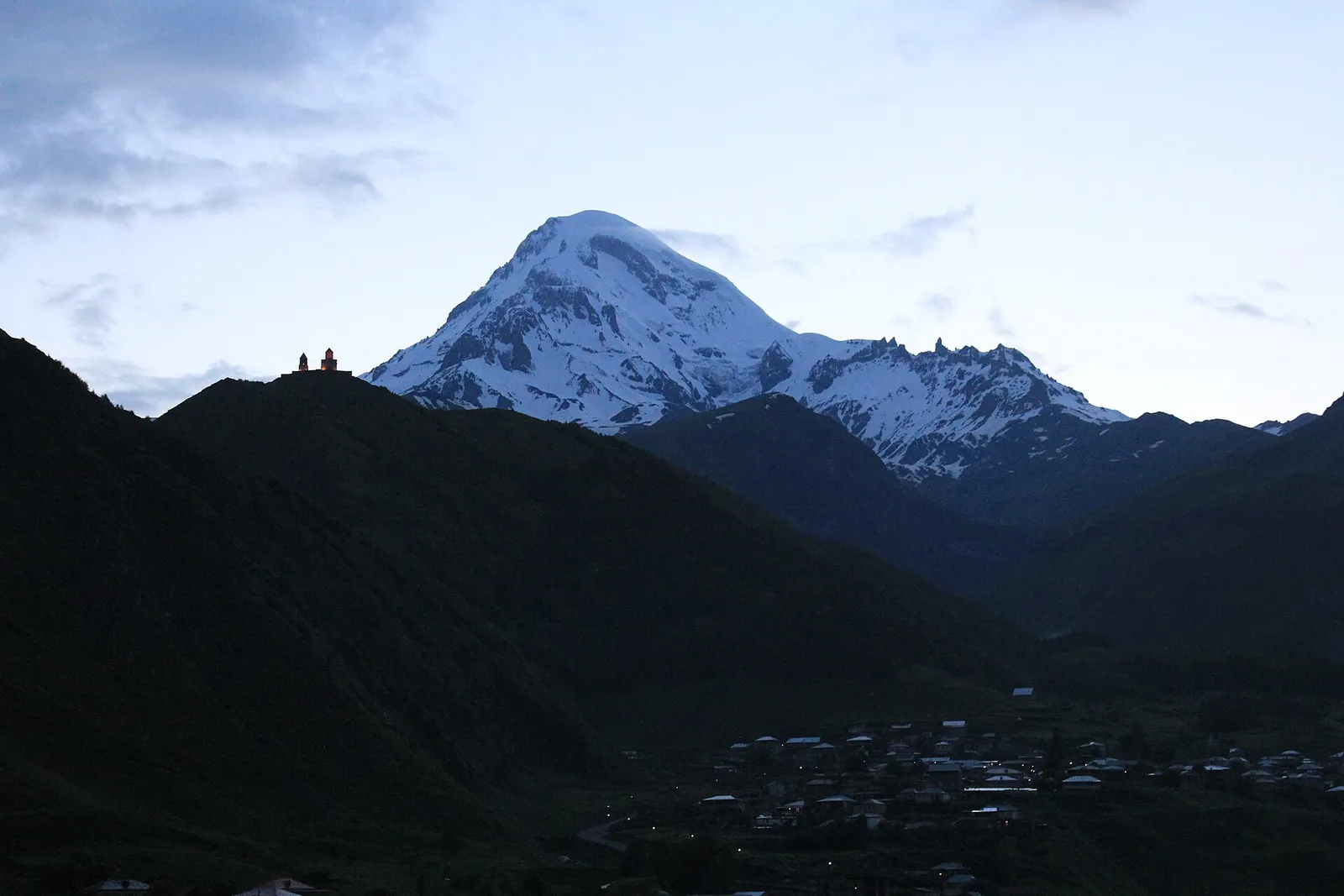 Gergeti Trinity Church on its hill with snow-capped Mount Kazbek behind