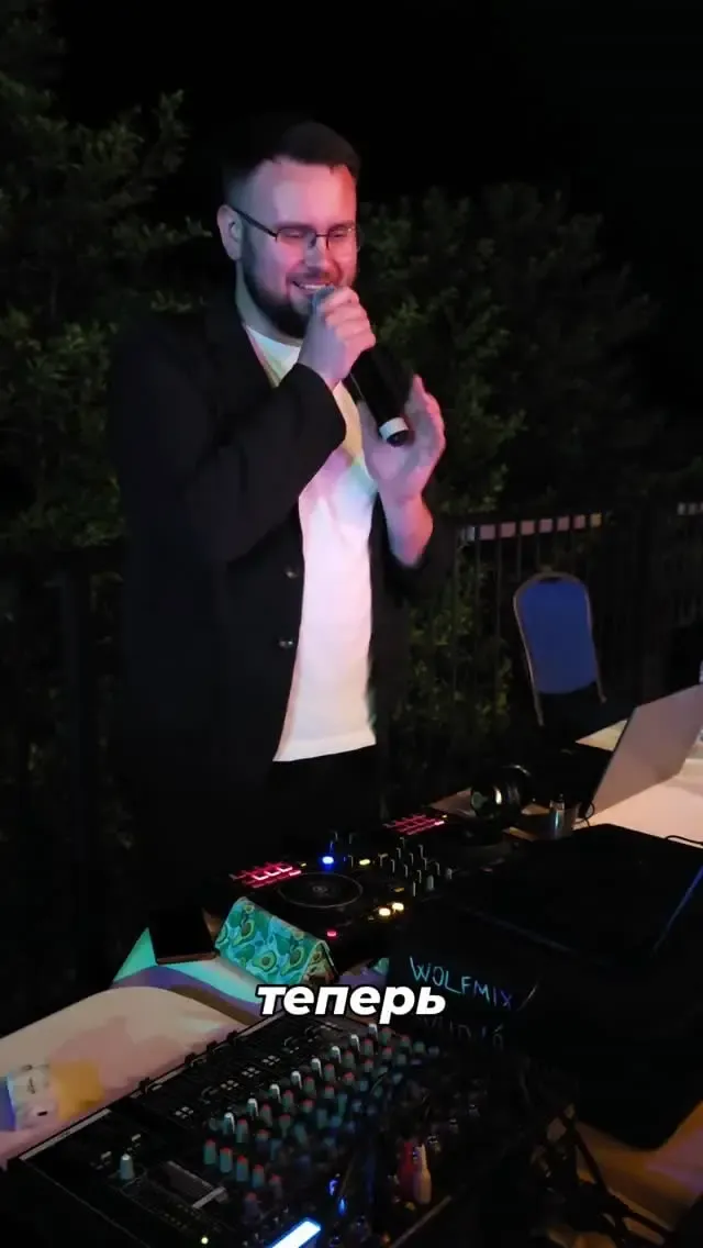DJ and sound engineer Evgeniy Govorun singing into a microphone behind the decks