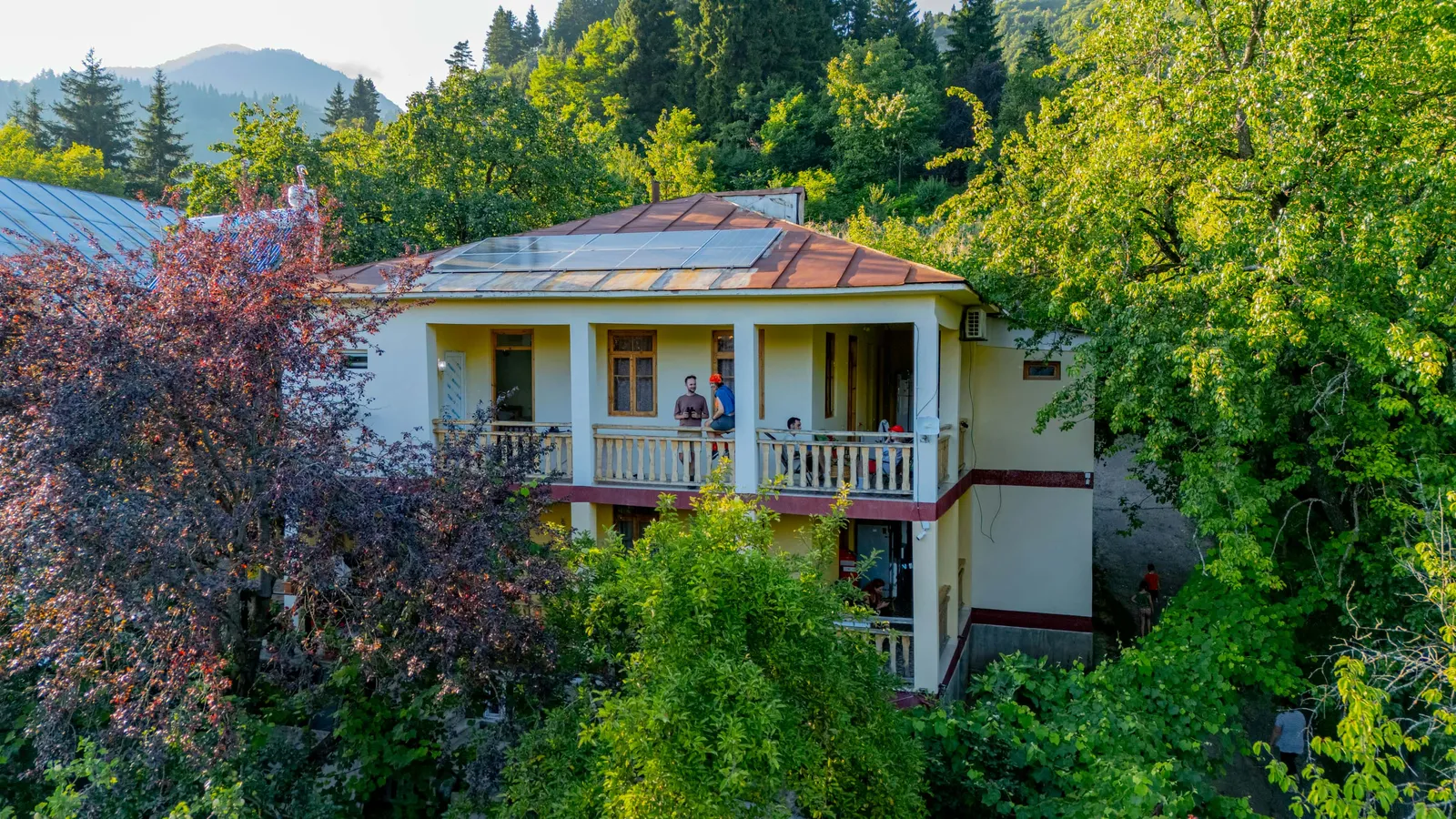 Rima's House, a two-storey guesthouse with balconies among trees in Vashlovani