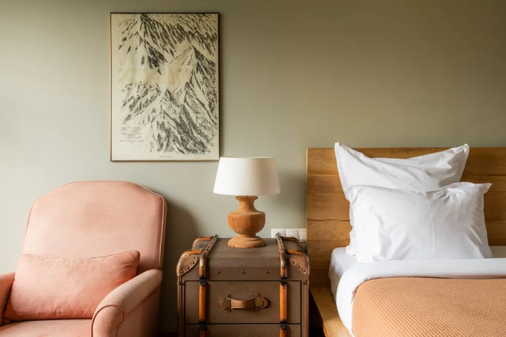 A guest room at Rooms Kazbegi with an armchair and a mountain print