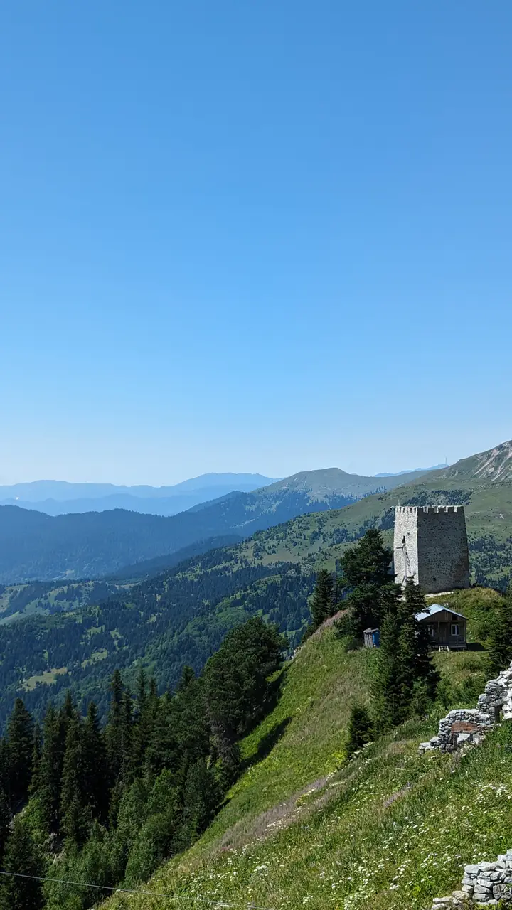 Khikhani Fortress on its green ridge, with distant mountains behind
