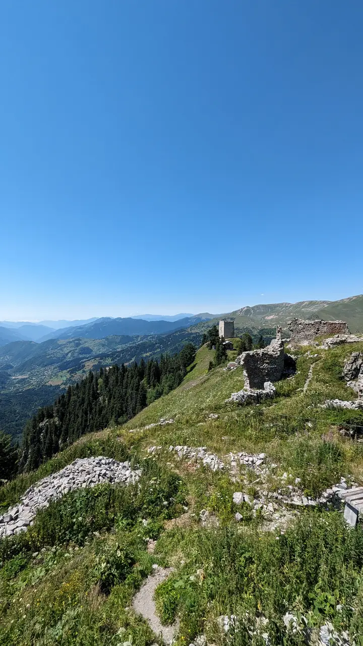 The ruined walls of Khikhani fortress along a green ridge, valleys below