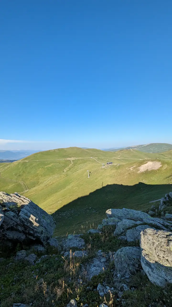 Green mountain meadows and rocks near the Goderdzi pass under a blue sky