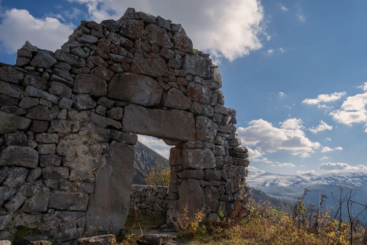 Stone walls of Khikhani Fortress with the mountains of upper Adjara behind them