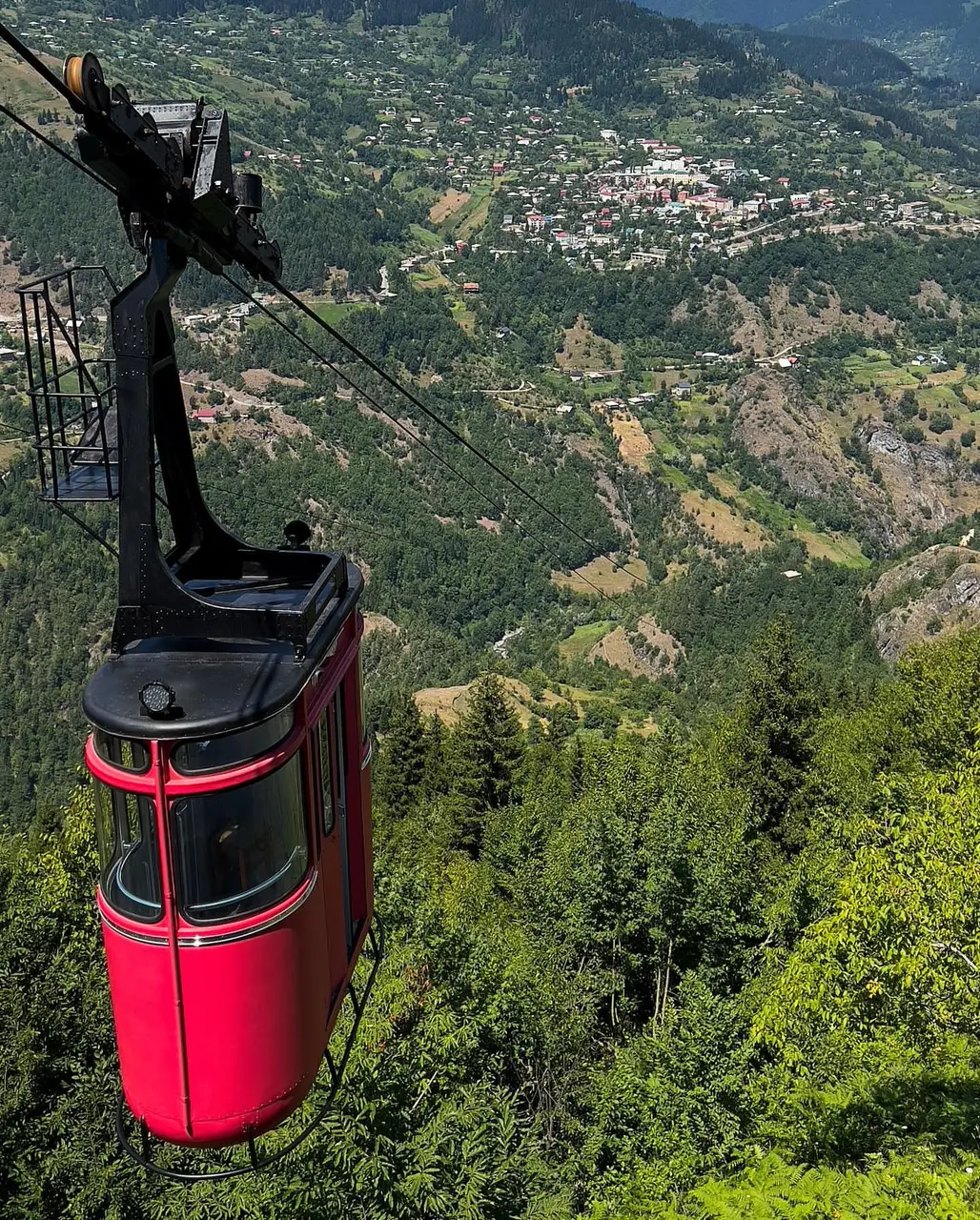 The red cabin of the Khulo to Tago cable car above the valley