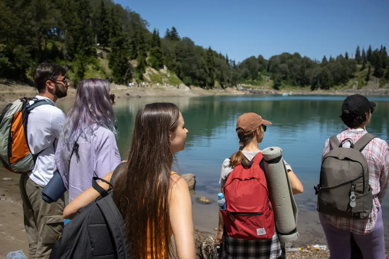 A group with backpacks and sleeping mats on the shore of Green Lake