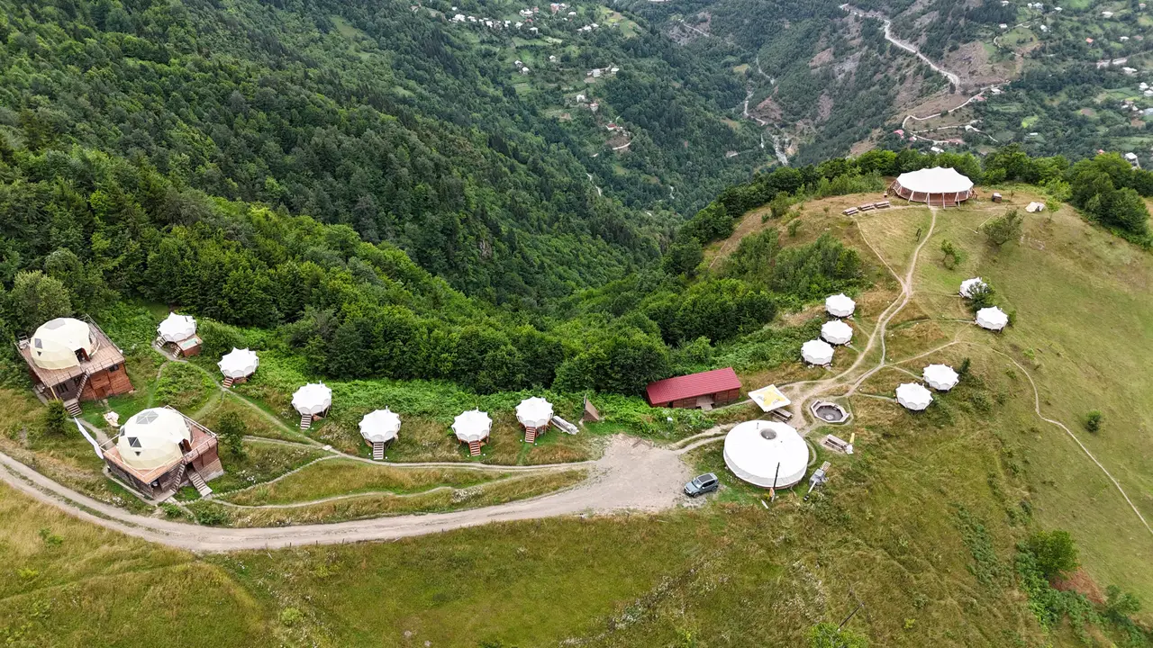 Aerial view of Glamping Tago tents and domes on the ridge above Village Tago
