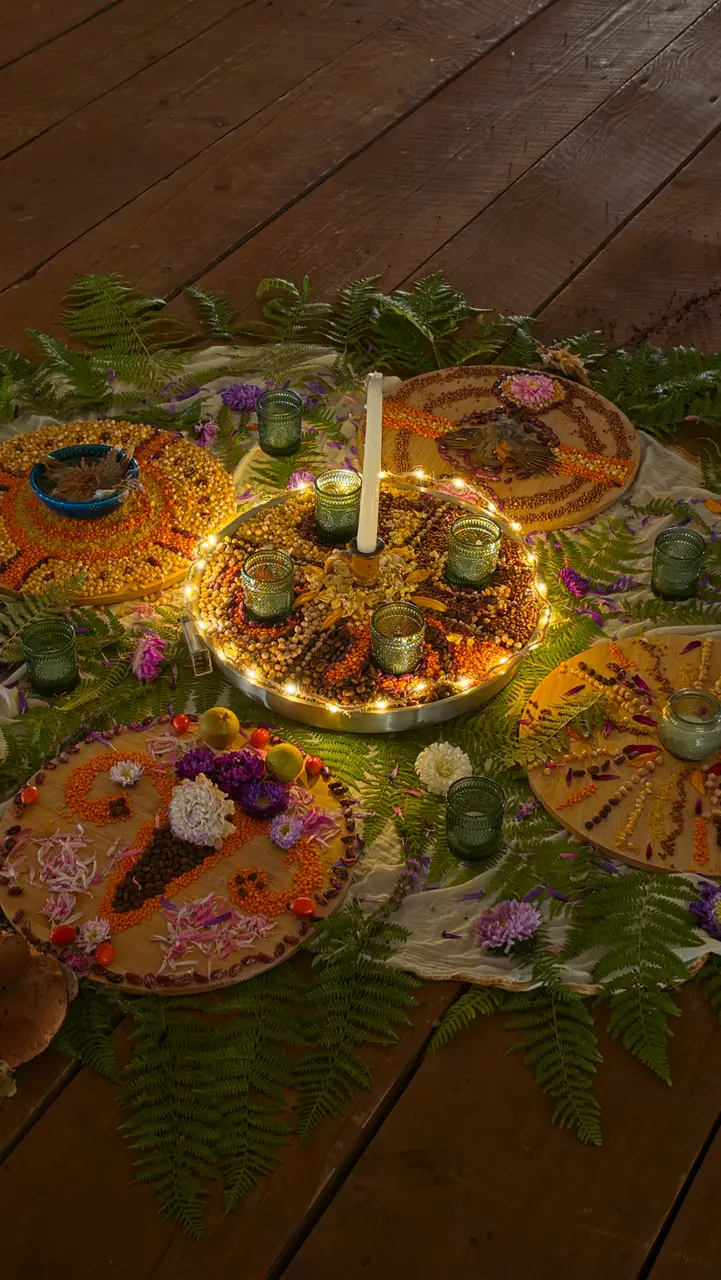 A table decorated with grains, lentils, flowers and candles on a wooden floor