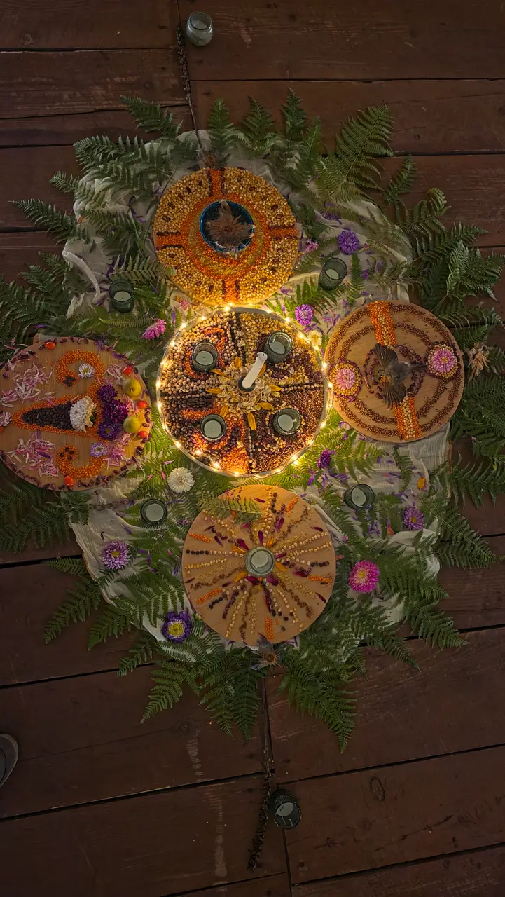 Wooden table platters decorated with grains, seeds, flowers, candles and ferns